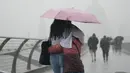 <p>Orang-orang dengan payung berjalan di tengah hujan di Jembatan Milenium, London, Rabu (17/8/2022). Setelah berminggu-minggu cuaca terik, yang telah menyebabkan kekeringan dan membuat tanah kering, peringatan badai petir kuning dari Kantor Meteorologi memperkirakan hujan lebat dan badai petir yang bisa melanda bagian Inggris dan Wales. (Victoria Jones/PA via AP)</p>