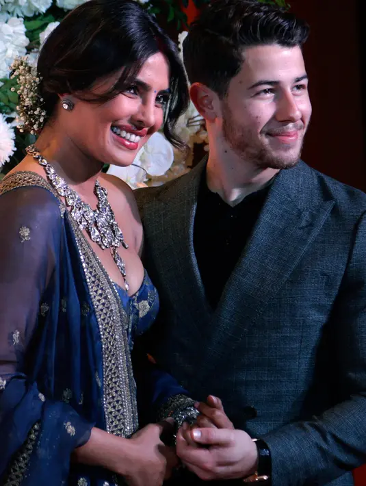 Pasangan Priyanka Chopra dan Jonas berpose untuk resepsi kedua pernikahan mereka di Mumbai, Rabu (19/12). Resepsi ketiga Priyanka Chopra dan Nick Jonas akan diadakan Kamis (20/12) malam dengan mengundang rekan selebritis Bollywood. (AP/Rajanish Kakade)