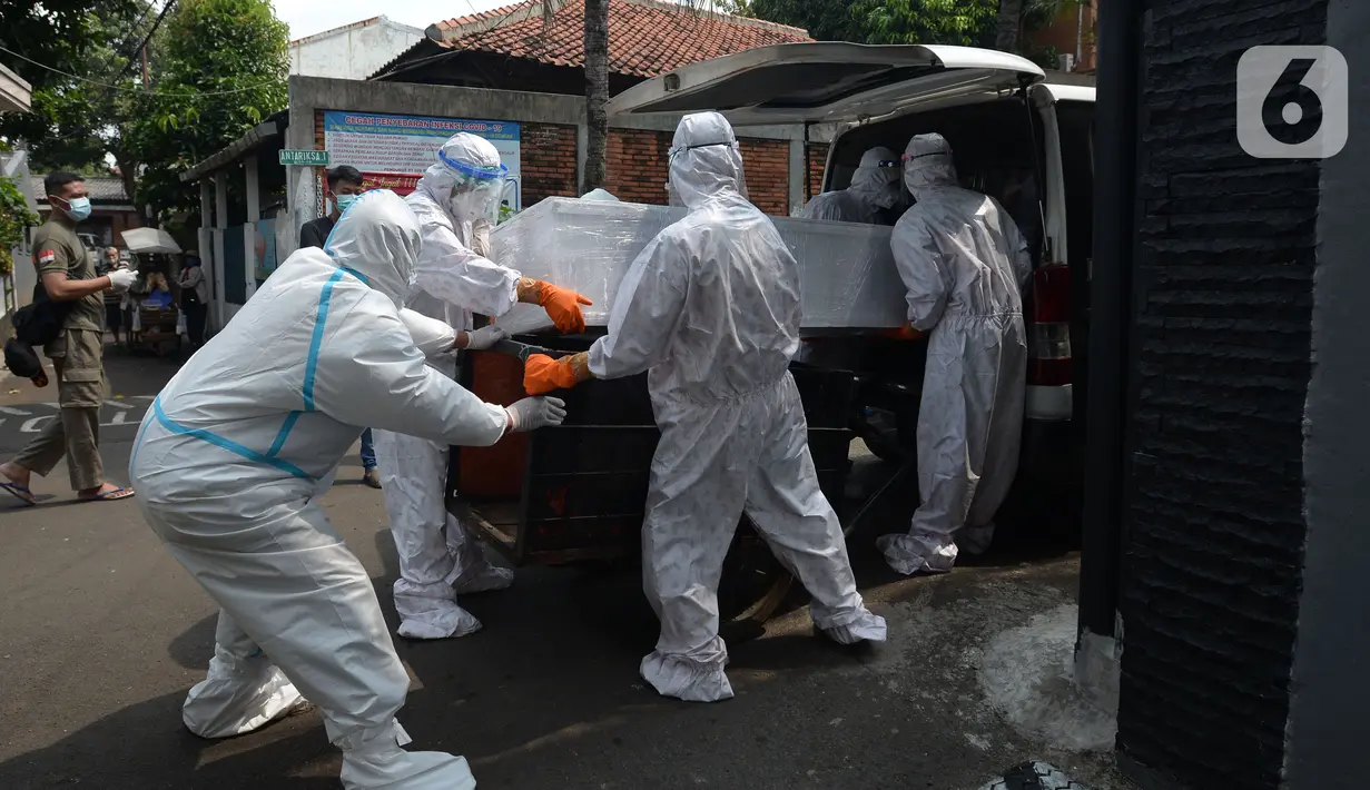 Petugas pemulasaraan jenazah Covid-19 memasukan peti jenazah yang meninggal ketika menjalani isolasi mandiri ke ambulans di Kampung Gedong, Jakarta, Sabtu (10/7/2021). Proses pemulasaran jenazah dilakukan sesuai prokes Covid-19 dikarenakan hasil test swab korban positif. (merdeka.com/Imam Buhori)