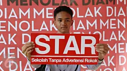 Siswa membentangkan poster STAR saat kegiatan 'Sekolah Tanpa Asap Rokok (STAR): Menolak Diam' di Taman Menteng, Jakarta, Sabtu (21/11). Aksi ini untuk mendeklarasikan penolakan menjadi target industri rokok melalui iklan. (Liputan6.com/Immanuel Antonius)