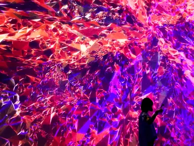 Seorang wanita berswafoto di depan instalasi seni audio visual berjudul “Cornerstone” di Today Art Museum, Beijing, Rabu (9/8). Pameran yang bertemakan ‘.zip’ ini menyajikan karya seni dari berbagai seniman di China. (AP/Andy Wong)