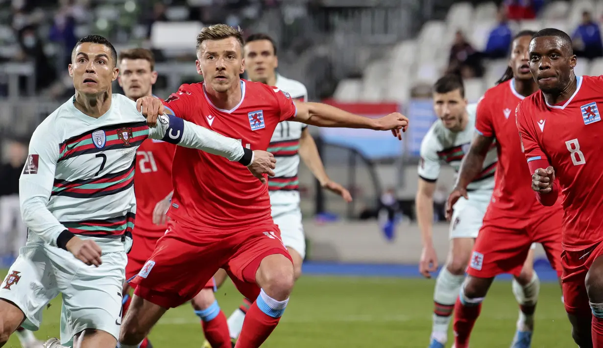 Striker Portugal, Cristiano Ronaldo (kiri) menunggu umpan sepak pojok dibayangi gelandang Luksemburg, Vincent Thill dalam laga Kualifikasi Piala Dunia 2022 Zona Eropa Grup A di Josy Barthel Stadium, Luksemburg, Selasa (30/3/2021). Portugal menang 3-1 atas Luksemburg. (AP/Olivier Matthys)
