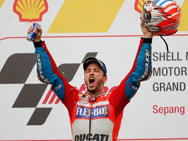 Pembalap Ducati Team, Andrea Dovizioso selebrasi di atas podium setelah berhasil memenangkan MotoGP Malaysia di sirkuit Sepang, Minggu (29/10). Dovizioso menyelesaikan balapan dengan catatan waktu 44 menit 51.497 detik. (AP/Vincent Thian)