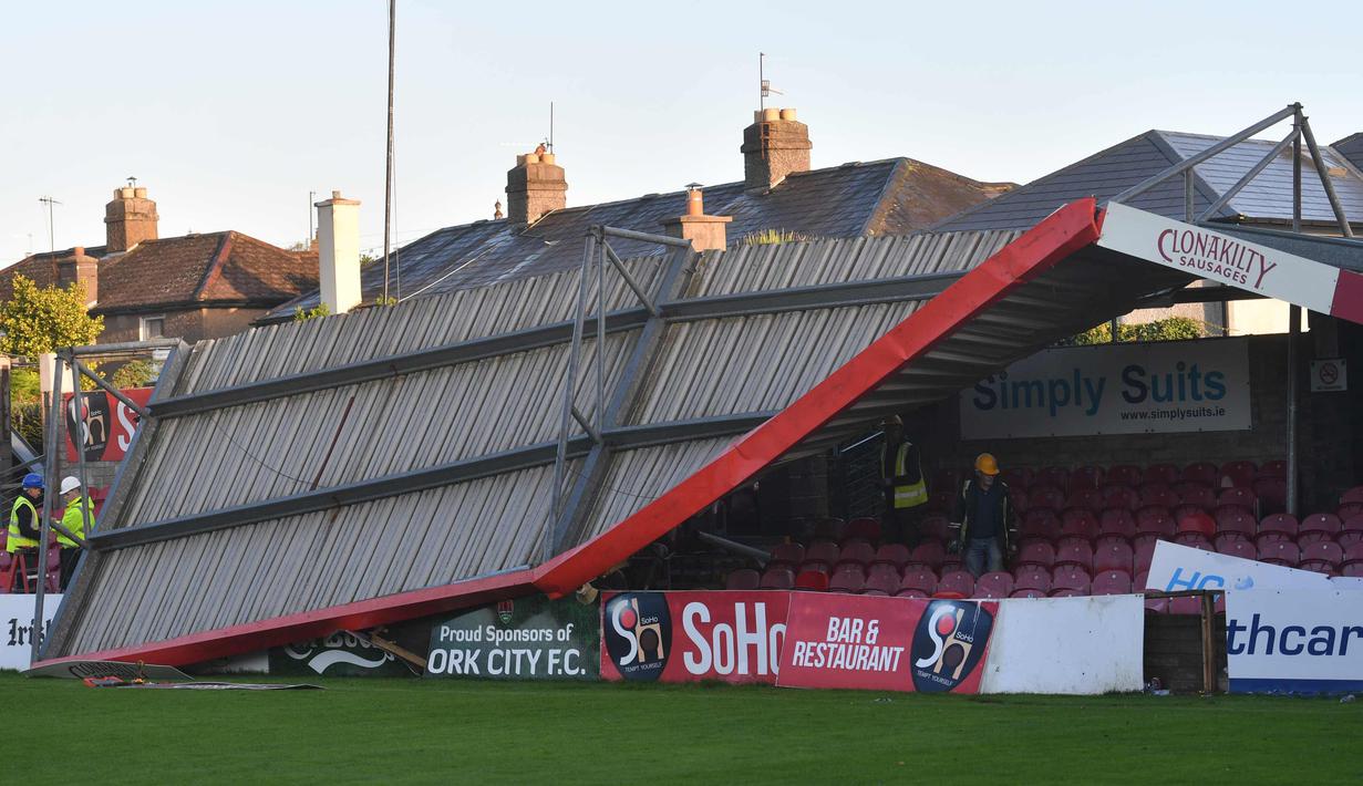Sejumlah pekerja memeriksa atap stadion Turners Cross usai diterjang badai Ophelia di kota Cork, Irlandia (17/10). Sejumlah sekolah dan kantor pemerintah ditutup akibat badai Ophelia ini. (AFP Photo/Ben Stansall)