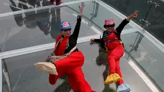 Dua turis berselfie saat mengunjungi wahana platform kaca di Shilin Gorge, Beijing, Cina, (27/5). Platform kaca ini merupakan yang terpanjang di dunia mengalahkan Grand Canyon. (REUTERS/Kim Kyung-Hoon)