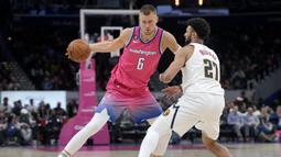 Pemain Washington Wizards, Kristaps Porzingis (kiri) berebut bola dengan pemain Denver Nuggets, Jamal Murray pada laga NBA 2023 di Capital One Arena, Washington, 22 Maret 2023. (AFP/Getty Images/Jess Rapfogel)