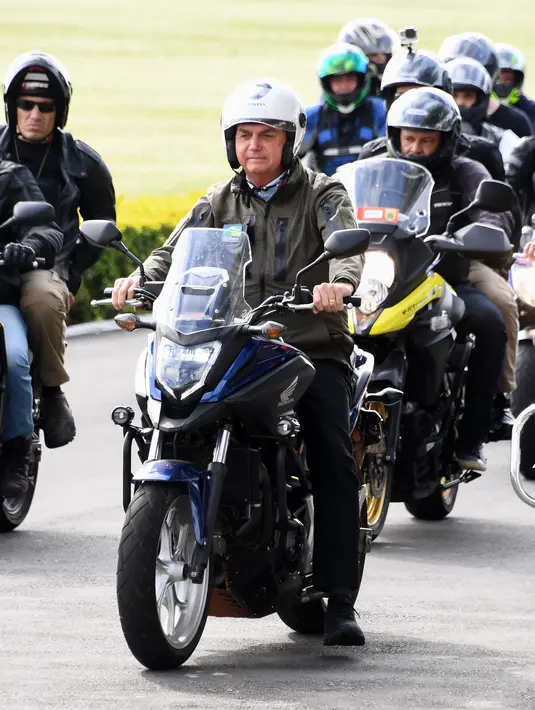 Presiden Brasil Jair Bolsonaro memimpin konvoi ratusan pengendara motor saat melakukan tur di Brasilia, di tengah COVID-19, Minggu (9/5/2021). Bolsonaro melakukan perjalanan dari istana presiden di Brasilia selama satu jam mengelilingi ibu kota Brasil untuk memperingati Hari Ibu. (EVARISTO SA/AFP)