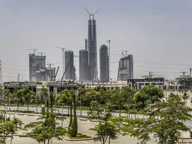 Gambar ini diambil pada 3 Agustus 2021 menunjukkan pemandangan gedung pencakar langit "Menara Ikon" (tengah) dan pekerjaan konstruksi lainnya yang sedang berlangsung di "distrik bisnis dan keuangan" megaproyek "Ibu Kota Administratif Baru" Mesir, sekitar 45 km timur Kairo. (Khaled DESOUKI/AFP)