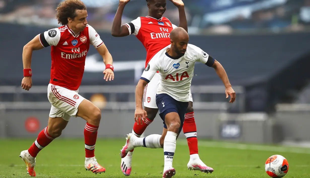 Gelandang Tottenham Hotspur, Lucas Moura menggiring bola dari kejaran dua pemain Arsenal, David Luiz dan Bukayo Saka pada pertandingan lanjutan Liga Inggris di Stadion Tottenham Hotspur di London, Inggris, Minggu (12/7/2020). Tottenham menang tipis atas Arsenal 2-1. (Tim Goode/Pool via AP)