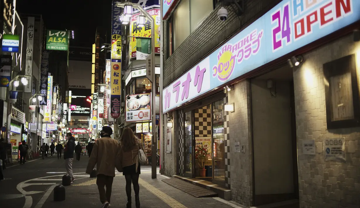 Orang-orang berjalan di sekitar lingkungan Shinjuku Tokyo, Kamis (7/1/2021). Proposal untuk deklarasi darurat disetujui pada pertemuan pagi, ujar Menteri Ekonomi Yasutoshi Nishimura. (AP Photo/Hiro Komae)