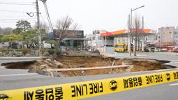 Insiden sinkhole atau lubang runtuhan terjadi di jalan sekitar daerah Myeongil-dong, distrik Gangdong-gu, kota Seoul pada pukul 18:30 waktu setempat pada Senin (24/3/2025) kemarin. (Anthony WALLACE/AFP)