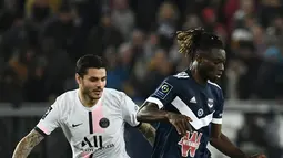 Penyerang Paris Saint-Germain (PSG) Mauro Icardi berebut bola melawan bek Bordeaux Gideon Mensah pada matchday ke-13 Liga Prancis 2021/2022 di Stadion Matmut Atlantique, Minggu (7/11/2021) dini hari WIB. PSG menang tipis 3-2, dengan dua gol disumbangkan Neymar. (Philippe LOPEZ/AFP)