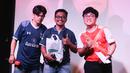 Seorang peserta kuis yang beruntung (tengah) mendapatkan merchandise dari sponsor berfoto bersama MC dalam acara Roaring Night Liga Inggris 2023/2024 antara Tottenham Hotspur kontra Arsenal di Treehaus Kemang, Minggu (28/4/2024) malam WIB yang digelar komunitas penggemar Tottenham Hotspur, IndoSpurs Jakarta. (Bola.com/Abdul Aziz)