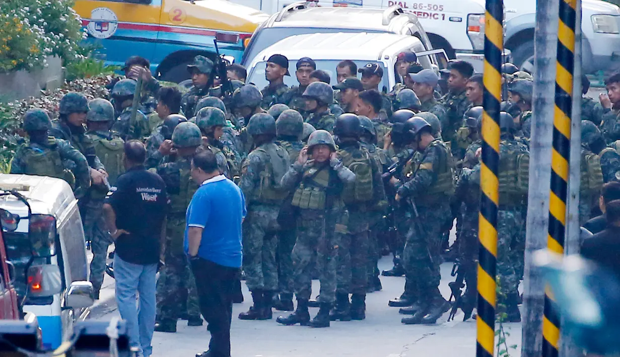 Pasukan Aksi Khusus Kepolisian Filipina bersiap memasuki area hotel Resorts World Manila, Jumat (2/6). Serangan pria bersenjata dilaporkan telah melukai puluhan tamu hotel dan kasino yang berlarian setelah penembakan muncul (AP Photo/Bullit Marquez)