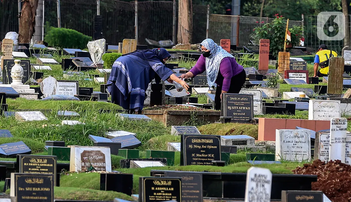 Warga menaburkan bunga di makam keluarganya di Tempat Pemakaman Umum (TPU) Tanah Kusir, Jakarta, Selasa (29/3/2022). TPU setempat semakin banyak dikunjungi warga yang melakukan tradisi ziarah kubur menjelang Ramadhan. (Liputan6.com/Johan Tallo)