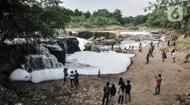 Wisatawan mengunjungi Curug Parigi yang tengah tercemar limbah busa di Cikiwul, Bantargebang, Bekasi, Jawa Barat, Minggu (19/7/2020). Destinasi wisata favorit warga Bekasi dan sekitarnya tercemar limbah sejak dua hari lalu sehingga menimbulkan busa dan bau tak sedap. (merdeka.com/Iqbal S. Nugroho)