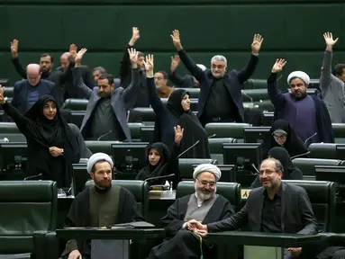 Anggota parlemen Iran mengangkat tangan saat voting RUU yang menetapkan pasukan militer Amerika Serikat sebagai teroris, Teheran, Selasa (7/1/2020). Parlemen Iran menetapkan pasukan militer Amerika Serikat teroris sebagai tanggapan atas kematian Jenderal Qasem Soleimani. (ICANA NEWS AGENCY/AFP)