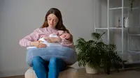 Seorang ibu muda yang sedang menggendong bayinya (Foto: Freepik/freepik).