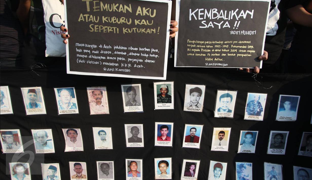 Aktivis JSKK membawa foto-foto korban pelanggaran HAM saat aksi Kamisan ke-455 di depan Istana Negara, Jakarta (18/8). Aktivis berharap agar pemerintah segera mengambil langkah konkret penyelesaian kasus pelanggaran HAM. (Liputan6.com/Immanuel Antonius)