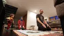 Ahmad Kamel (depan) melaksanakan salat Maghrib dengan istrinya, Nadia Chaouch, ketika putra mereka Ahmad Kamel berlari melewati setelah keluarga berbuka puasa saat bulan Ramadan selama wabah Covid-19 di rumah mereka di Seattle (28/4/2020). (AP/Elaine Thompson)