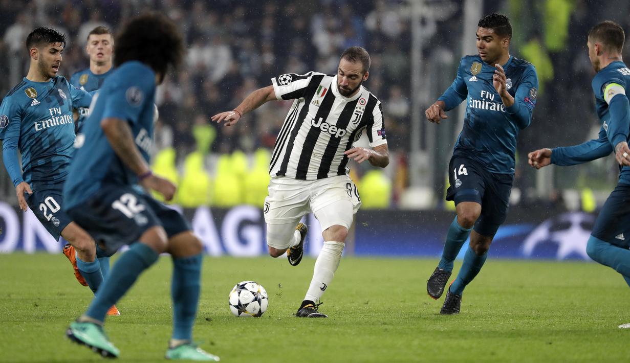 Striker Juventus, Gonzalo Higuain, berusaha melewati pemain Real Madrid pada laga Liga Champions di Stadion Allianz, Selasa (3/4/2018). Juventus takluk 0-3 dari Real Madrid. (AP/Luca Bruno)