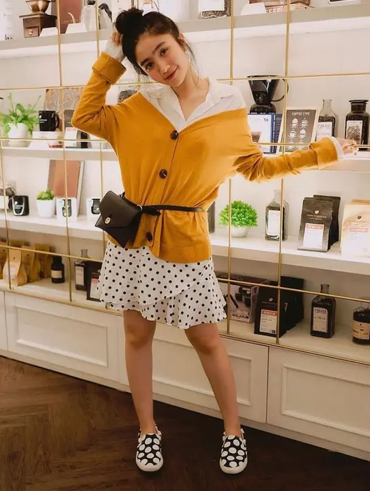 Tampil lebih feminim, dengan padu padan kemeja putih dan rok polkadot ruffle. Untuk outer, pilih cardigan warna mustard. (Instagram/febbyrastanty).