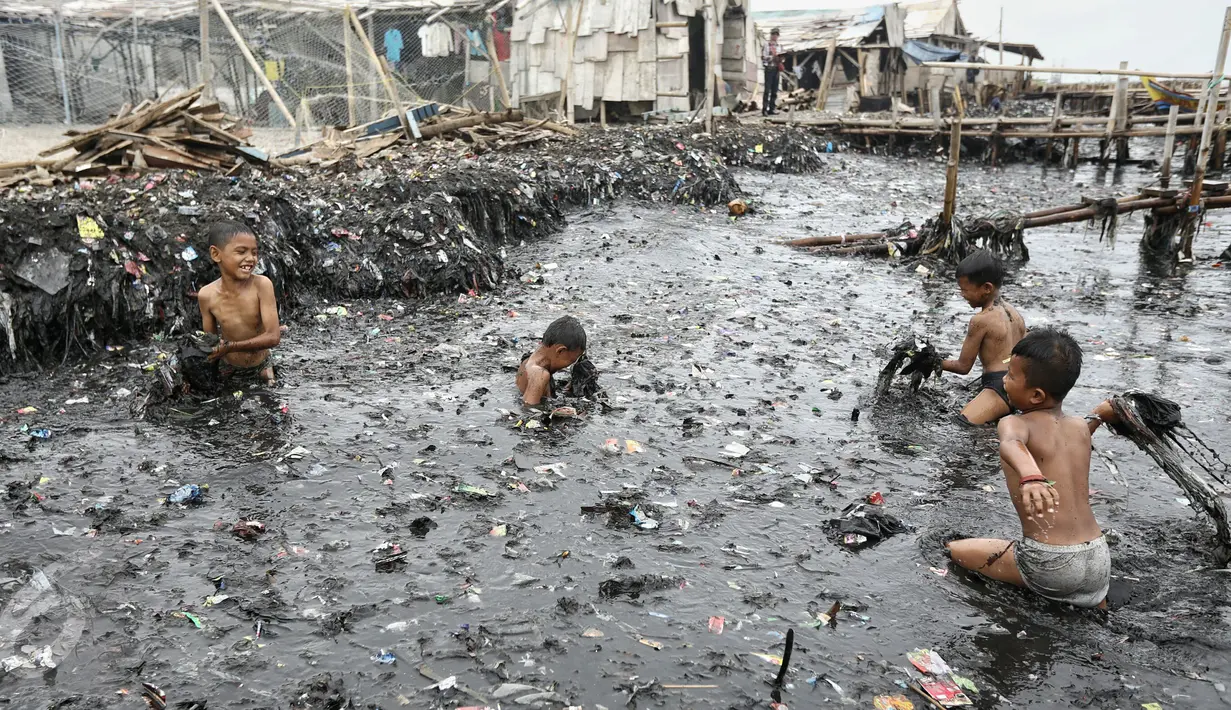 Anak-anak bermain air di kawasan pantai penuh sampah yang terbawa arus di Muara Angke, Jakarta, Rabu (10/2). Genangan sampah yang terbawa arus oleh angin musim barat ini tak menyurutkan anak-anak untuk bermain air. (Liputan6.com/Faizal Fanani)