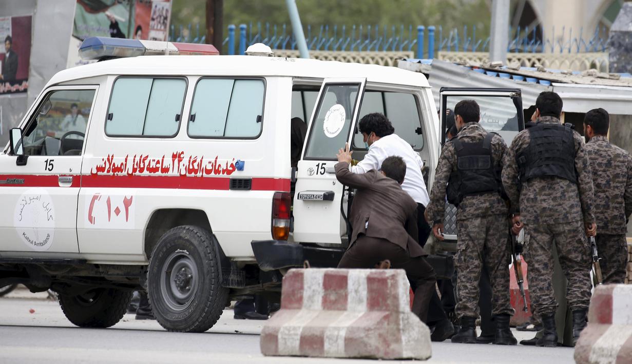 Pasukan keamanan mengevakuasi petugas yang terluka ke dalam ambulans setelah ledakan bom di Kabul, Selasa (19/4). Belum ada pihak yang mengklaim soal siapa di balik serangan ini. Tetapi dugaan terkuat tertuju pada kelompok Taliban. (REUTERS/Omar Sobhani)