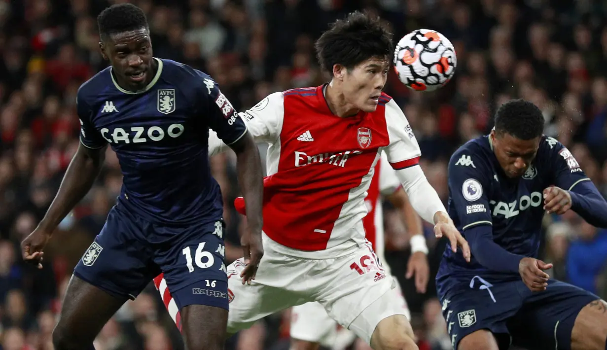 Bek Arsenal, Takehiro Tomiyasu (tengah) berebut bola udara dengan pemain Aston Villa, Axel Tuanzebe selama pertandingan lanjutan Liga Inggris di i stadion Emirates di London, Sabtu (23/10/2021). Arsenal menang atas Aston Villa dengan skor 3-1. (AP Photo/Ian Walton)