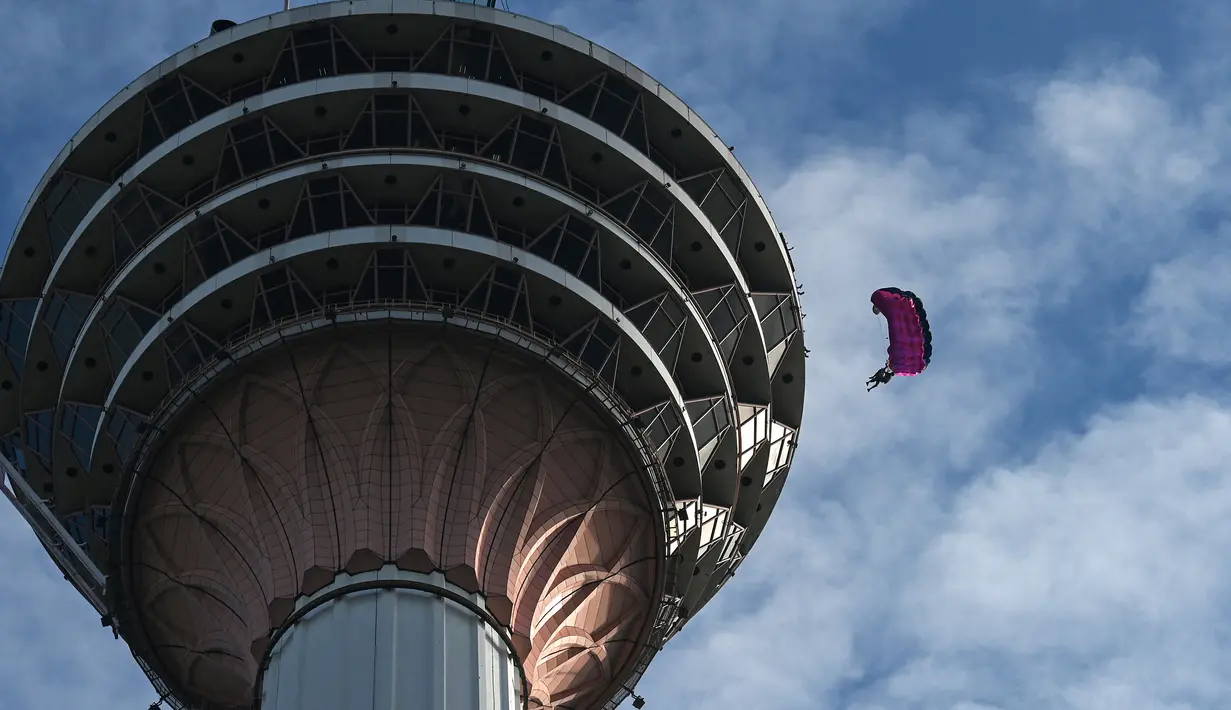 Para penerjun melompat dari dek terbuka Menara Kuala Lumpur saat International Tower Jump, Kuala Lumpur, Malaysia, 3 Februari 2023. Lebih dari 100 penerjun melompat dari Menara Kuala Lumpur setinggi 300 meter yang terkenal tersebut. (MOHD RASFAN/AFP)