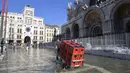 Orang-orang berjalan di St. Mark's Square yang terendam banjir di Venesia, Italia, Jumat (5/11/2021). Setelah Venesia mengalami banjir terparah kedua dalam sejarahnya pada November 2019, kota itu dibanjiri empat kali pasang luar biasa dalam waktu enam minggu. (AP Photo/Luigi Costantini)