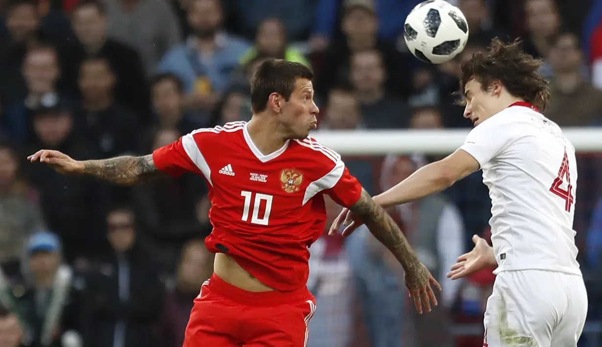 Duel pemain Russia, Fyodor Smolov (kiri) dan pemain Turki, Caglar Soyuncu pada laga uji coba di VEB Arena stadium, Moskow, Rusia, (5/6/2018). Rusia bermain imbang 1-1. (AP/Pavel Golovkin)