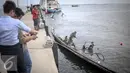 Sejumlah warga melihat bangkai kapal Zahro yang terlihat hangus di pelabuhan Muara Angke, Jakarta, Selasa (3/1). Bangkai Kapal Zahro Express rencananya akan diangkat ke daratan Dermaga Pelabuhan Muara Angke. (Liputan6.com/Faizal Fanani)