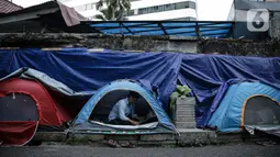 Seorang pengungsi Afghanistan berada di dalam tenda di trotoar Kawasan Kebon Sirih, Jakarta, Kamis (26/8/2021). Sebanyak 20 pengungsi asal Afghanistan kembali menempati trotoar dengan harapan bisa diterbangkan ke negara lain dan mendapatkan kehidupan yang lebih layak. (Liputan6.com/Faizal Fanani)