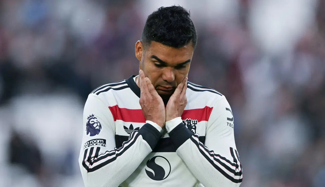 Pemain Manchester United, Casemiro, tampak kecewa setelah ditaklukkan West Ham United pada laga pekan ke sembilan Liga Inggris di Stadion London, Minggu (27/10/2024). Setan Merah tumbang dengan skor 1-2. (AFP/Glyn Kirk)