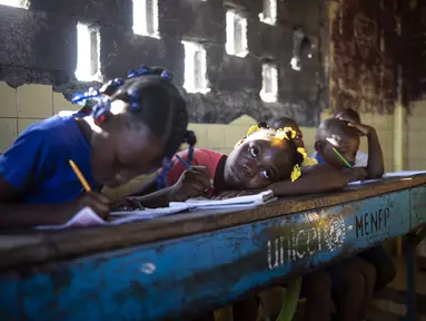 Para siswa menulis saat menghadiri kelas di sekolah Sante Bernadette, di dalam Fort Dimanche di Port-au-Prince, Haiti, Kamis (23/9/2021). Sekolah ini pernah menjadi penjara di mana mendiang diktator Francois "Papa Doc" Duvalier memenjarakan musuh-musuhnya. (AP Photo/Rodrigo Abd)