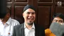 Tawa terdakwa perkara ujaran kebencian Ahmad Dhani saat menjalani sidang lanjutan di PN Jakarta Selatan, Senin (14/5). Majelis hakim menolak nota keberatan (eksepsi) Ahmad Dhani. (Liputan6.com/Immanuel Antonius)