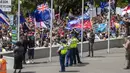 Petugas kepolisian berjaga saat pengunjuk rasa berkumpul di gedung Parlemen Selandia Baru, di Wellington, Selasa (9/11/2021). Ribuan warga Selandia Baru berdemonstrasi memprotes kebijakan vaksin covid-19 dan penguncian (lockdown) yang diterapkan negara itu. (Mark Mitchell/NZ Herald via AP)
