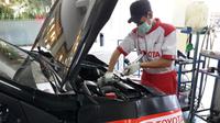 Seorang mekanik sedang melakukan pengecekan mobil di bengkel Toyota Auto2000. (dok Auto2000)