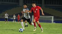 Pemain Timnas Indonesia U-16, Matthew Baker (kanan) menguasai bola dibayangi seorang pemain SKO Ragunan pada laga uji coba di Stadion Manahan, Solo, Rabu (12/6/2024) menjelang keikutsertaan Timnas Indonesia U-16 pada ajang Piala AFF U-16 2024. (Bola.com/Radifa Arsa)
