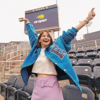 Nonton final US Open bersama rombongan Erigo, Enzy Storia tampil sporty kasual memadukan crop top putih sebagai inner dan jaket biru sebagai outer. Kesan feminin pun ditambahkan lewat celana rok  berwarna lilac yang ia kenakan sebagai bawahan.  (Instagram/enzystoria).