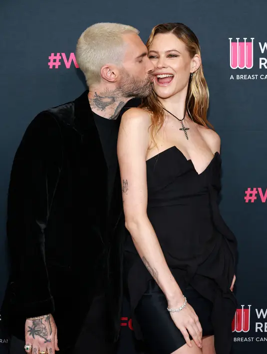 Sementara Prinsloo memakai gaun mini hitam yang memamerkan kakinya yang kencang, dan tumit cetak cheetah yang chic. Rocker itu memeluk dan mencium pipi istrinya yang merupakan model Victoria's Secret. (Matt Winkelmeyer/Getty Images/AFP)