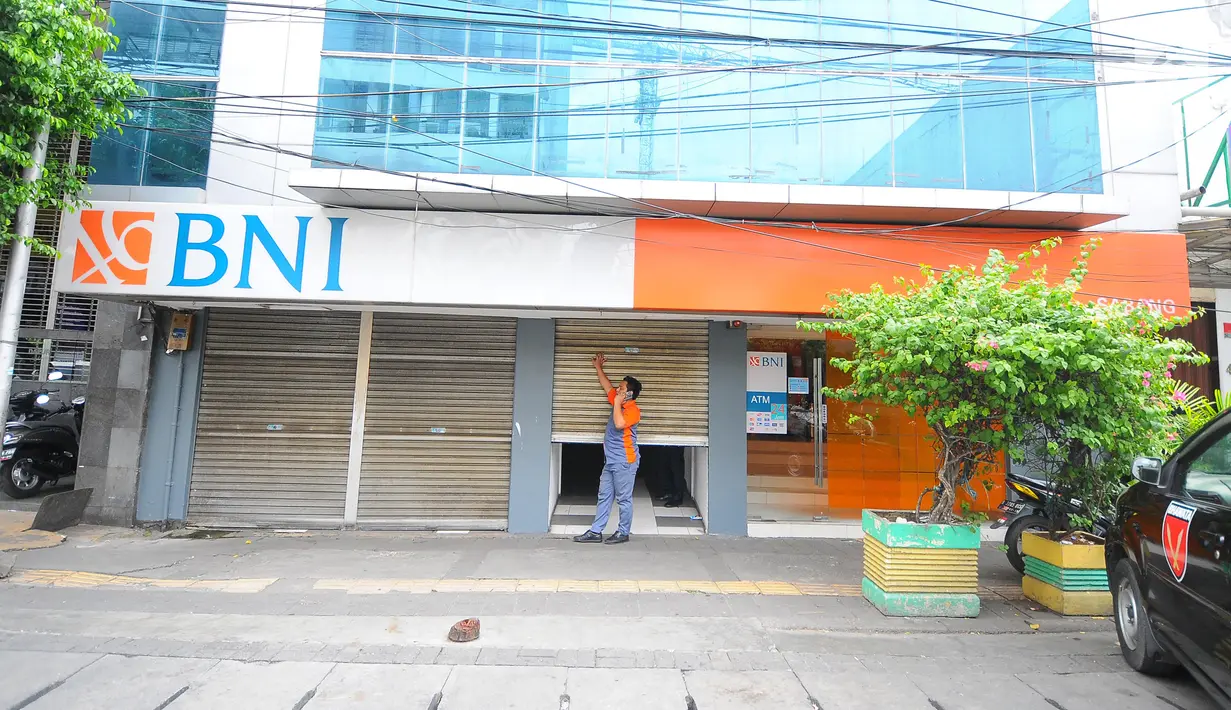 Petugas menutup "rolling door" kantor BNI yang berada di Jalan Sabang, Jakarta pada Rabu (22/5/2019). Pemilik toko dan pengelola kantor di kawasan tersebut menutup toko dan kantor mereka imbas aksi 22 Mei 2019 yang berakhir rusuh di beberapa titik lokasi. (Liputan6.com/Aangga Yuniar)