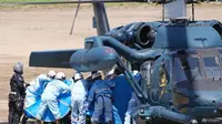 Personil darurat memindahkan orang yang diselamatkan di Shari, di pulau utara Hokkaido pada 24 April 2022. (Foto: Koki Sengoku/Kyodo News via AP)
