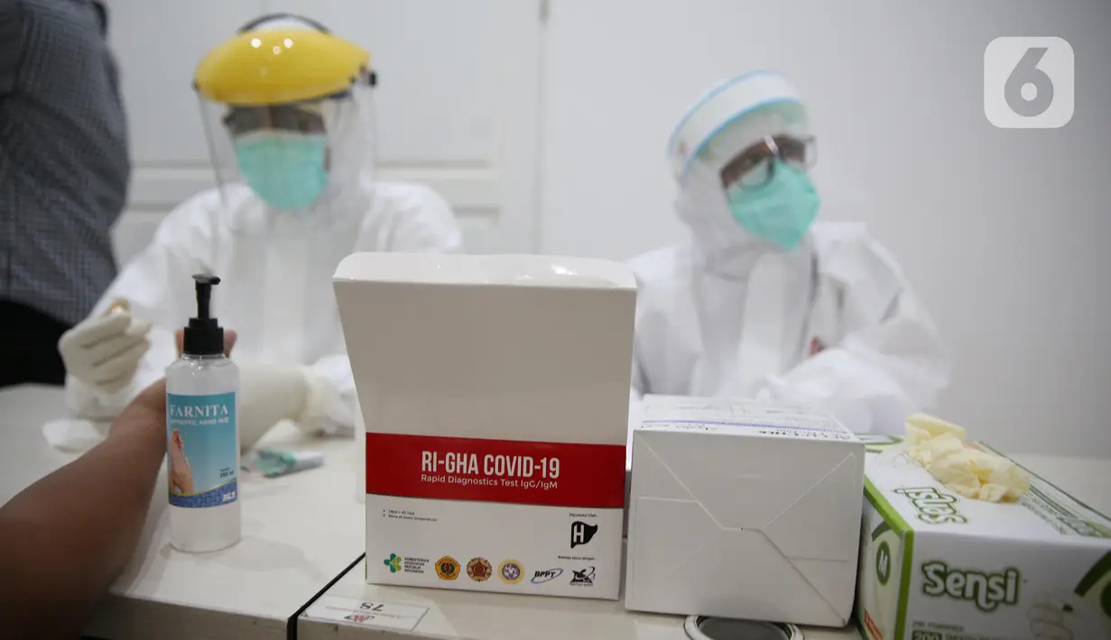 Petugas medis melakukan Rapid Tes menggunakan alat produksi dalam negeri di Kantor Kemenko PMK, Jakarta, Kamis (9/7/2020). Pemerintah RI Melalui Kemenko PMK bersama sejumlah kementerian dan lembaga terkait meluncurkan produk tes cepat Covid-19. (Liputan6.com/Faizal Fanani)