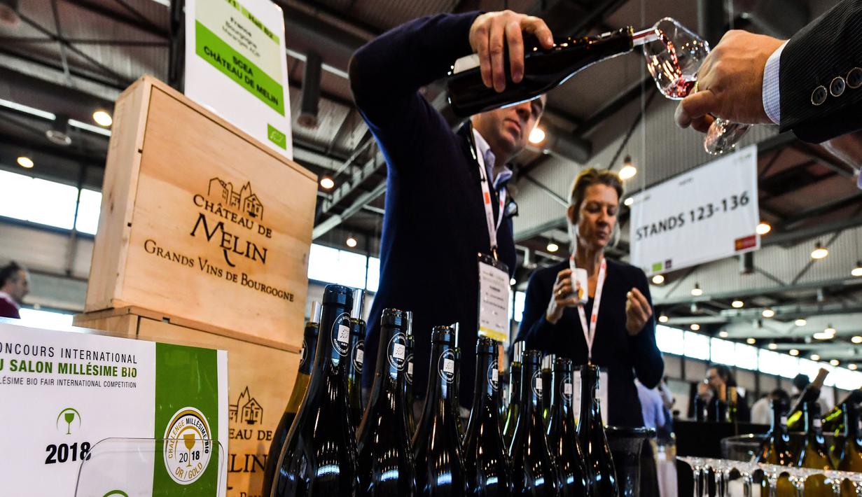 Pelayan menuangkan wine organik kepada pengunjung pameran Millesime Bio 2018 di Kota Montpellier, Prancis, Senin (29/1). (AFP PHOTO/PASCAL GUYOT)