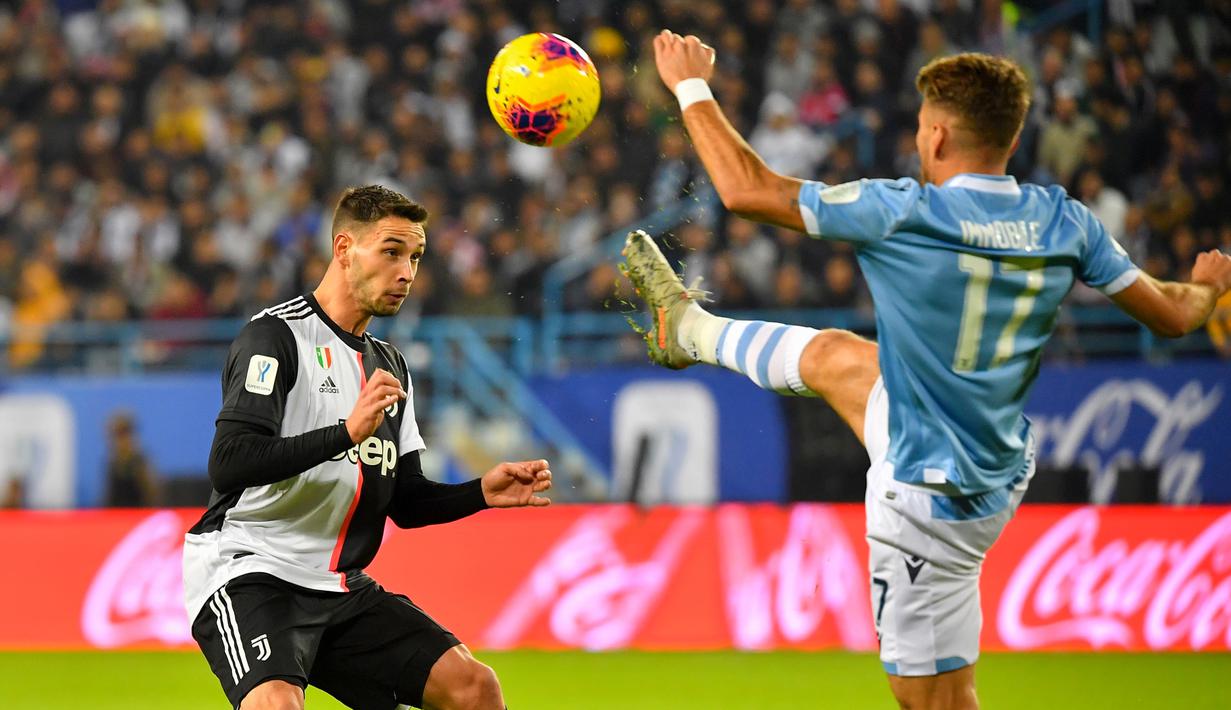Pemain Juventus, Rodrigo Bentancur, berebut bola dengan striker Lazio, Ciro Immobile, pada laga Piala Super Italia 2019 di Stadion King Saud University, Arab Saudi, Minggu (22/12). Lazio menang 3-1 atas Juventus. (AFP/Giuseppe Cacace)