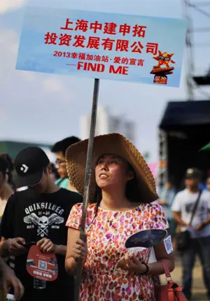 Keterangan foto: Seorang perempuan tengah memegang papan nama di sebuah acara perjodohan di Pantai Jinshan, Shanghai, 20 Juli 2013. Credit: REUTERS/Carlos Barria 