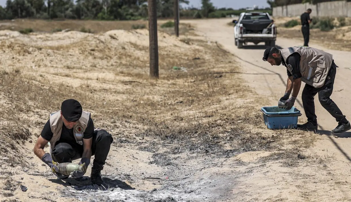 Pakar bahan peledak Hamas mengambil proyektil yang tidak meledak setelah konflik Mei 2021 dengan Israel dari sebuah lapangan di Khan Yunis, Jalur Gaza, Sabtu (5/6/2021). Perang 11 hari antara Hamas dan Israel menewaskan 254 orang Palestina dan 12 orang Israel. (MAHMUD HAMS/AFP)