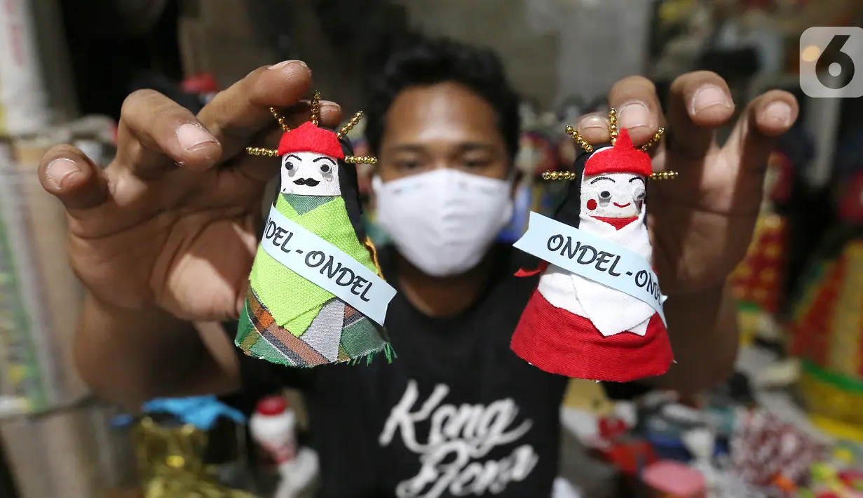 Pekerja menunjukkan ondel-ondel dari shuttlecock atau kok bekas di perkampungan Budaya Betawi, Srengseng Sawah, Jakarta, Sabtu (8/8/2020). Menyambut HUT Kemerdekaan RI produksi ondel-ondel dengan harga Rp 5 ribu per buahnya mulai banyak diburu. (Liputan6.com/Fery Pradolo)